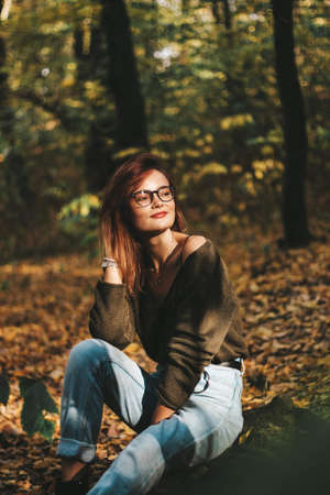 autumn photo session of a beautiful girl with dark hair in the forest.の写真素材