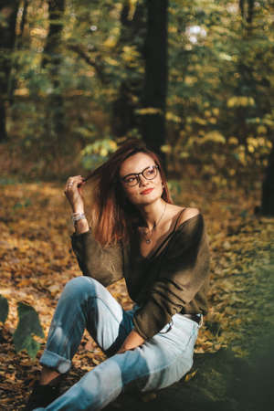 autumn photo session of a beautiful girl with dark hair in the forest.の写真素材