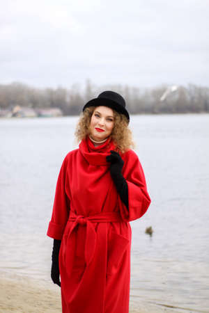 a very sad curly-haired girl in a bright raincoat with emotions on her face.の写真素材