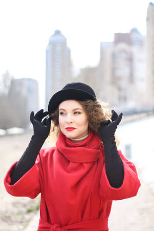 a very sad curly-haired girl in a bright raincoat with emotions on her face.の写真素材