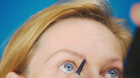 super close-up, woman paints eyebrow pencil for eyebrows. woman doing her makeupの写真素材