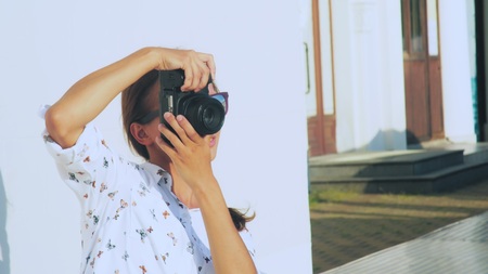The girl photographer shoots the model in the open air, close-up, the lens of the camera.の写真素材