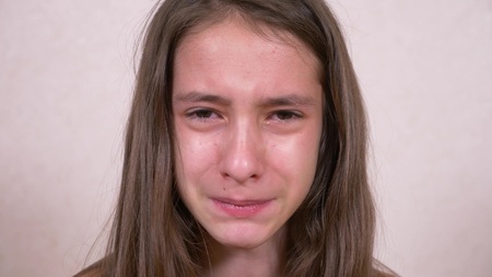 girl teenager crying looking into the cameraの写真素材