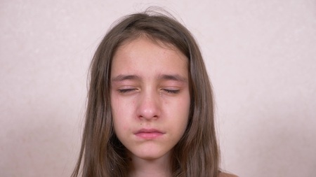 girl teenager crying looking into the cameraの写真素材