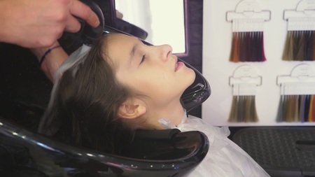 close-up, Professional hairdresser. process of painting the hair of a brunette girl with a toning tonic for hair. washing headの写真素材