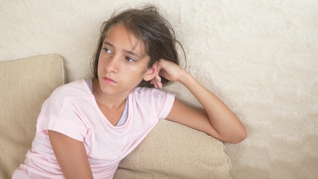 portrait of a sad girl. who sits on the couch.の写真素材