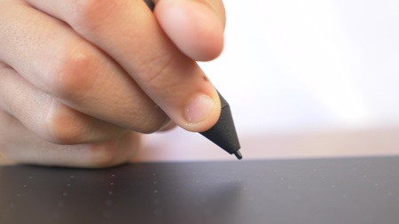 Closeup. hand holding stylus, draws on a graphic tabletの写真素材