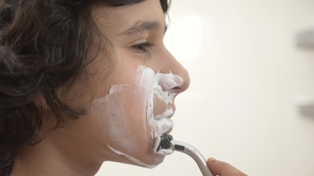 Teenager shaves first time, teenage boy applying shaving foam, skincare, cream, face, close-upの写真素材