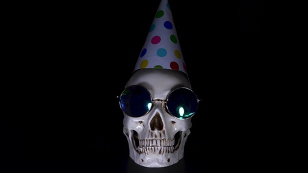 Halloween. the skull in a festive cap on a black background.の写真素材