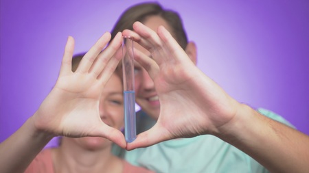close-up . couple man and woman hugging. on a colored background with a test tube in his hand. concept of IVF.の写真素材