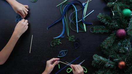 Creative paper Christmas tree. Quilling. childrens hands make quilting crafts for the new year. copy space, close-upの写真素材