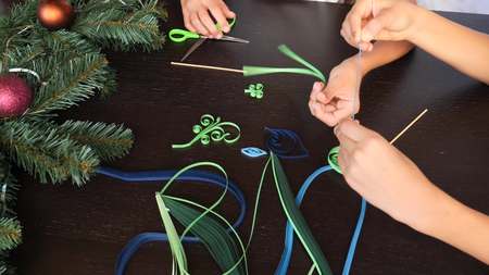 Creative paper Christmas tree. Quilling. childrens hands make quilting crafts for the new year. copy space, close-upの写真素材