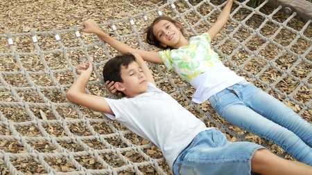 Pair of happy children boy and girl on hammock. copy spaceの写真素材
