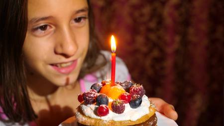 Birthday of the little girl she blows out candles on cake.の写真素材