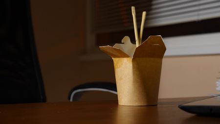 A businessmans table with fast food. Late dinner at the office. copy spaceの写真素材