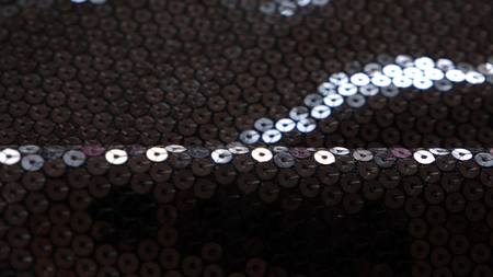 fabric as background. black knitted fabric with paillettes