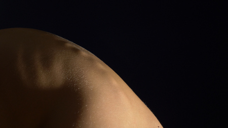 young woman with naked back on a black background. concept of health back, spine. copy spaceの写真素材