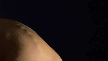 young woman with naked back on a black background. concept of health back, spine. copy spaceの写真素材