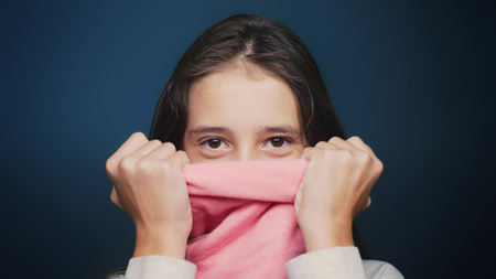 beautiful teen girl in autumn clothes , posing at camera over blue backgroundの写真素材