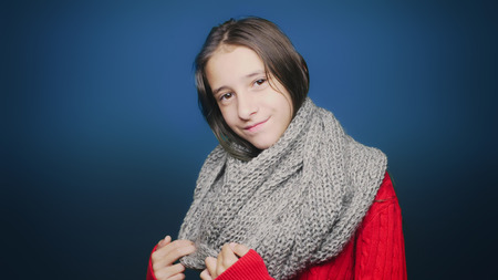 beautiful teen girl in autumn clothes , posing at camera over blue backgroundの写真素材