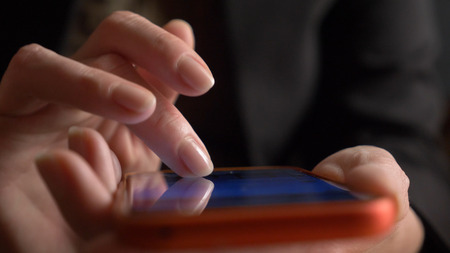 close-up, womans fingers on the touchscreen of the smartphone. woman uses a mobile phone