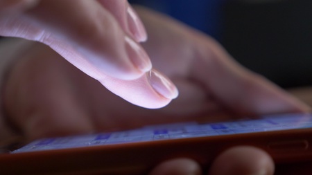 close-up, womans fingers on the touchscreen of the smartphone. woman uses a mobile phone