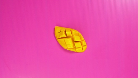 tropical fruit on a bright pink background. Pineapple slices and yellow mangoes. Minimal fruit concept.の写真素材