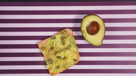 avocado on toast bread with spices on a striped black white background. The concept of healthy eating.の写真素材