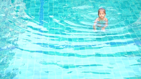 asian cute little girl playing in the poolの写真素材