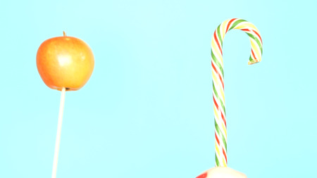 Concept of healthy and unhealthy food. Apple against a candy on a bright blue backgroundの写真素材