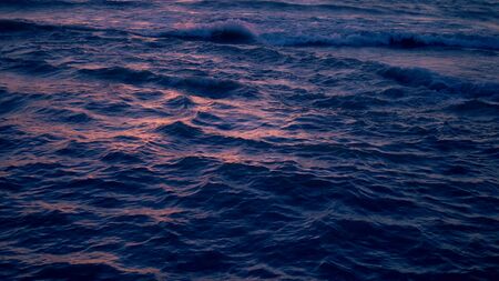 beautiful sunset on the sea, sea waves and colorful skyの写真素材