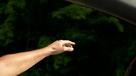 close-up. drivers hand from the car window. concept of freedom and autotravel