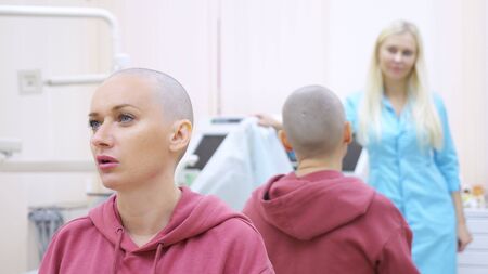 bald woman at a consultation with a doctor in a clinic. The concept of trichology, oncology,...