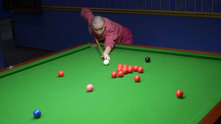 bald woman plays billiards. snooker. game of billiards in a billiard club