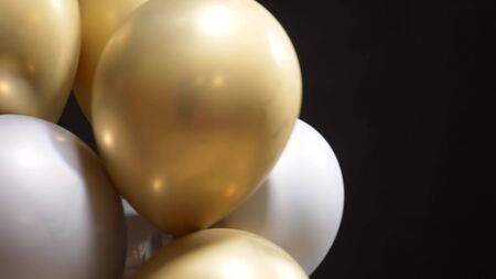 a lot of balloons of gold and silver soar on black backgroundの写真素材