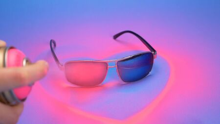 sunglasses are painted pink with spray paint on a blue background