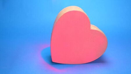 Coloring box in the shape of a heart, pink spray paint. blue background
