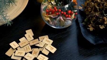 mystical background. dry herbs, runes, and a burning candle on the tableの写真素材