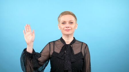 Stylish elegant woman is waving. blue background. gestures