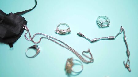 silver jewelry and black pouch on a blue backgroundの写真素材