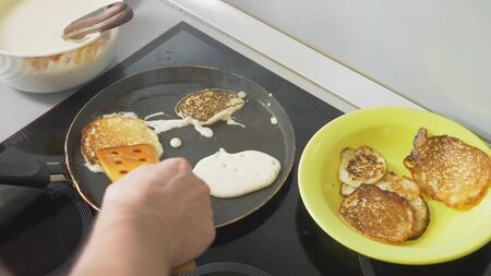close up, someone is cooking pancakes in a pan on a touch stove