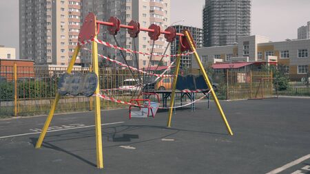 Empty playground during the coronavirus pandemic. warning tapes on the ridesの写真素材
