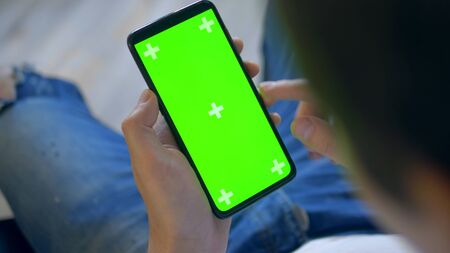 closeup. chroma key screen of a smartphone. man uses cell phoneの写真素材
