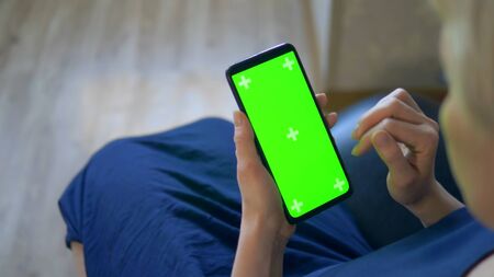 closeup. chroma key screen of a smartphone. woman uses cell phoneの写真素材