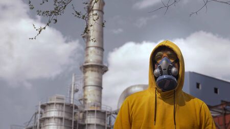 man in respirator against the background of factory chimneysの写真素材