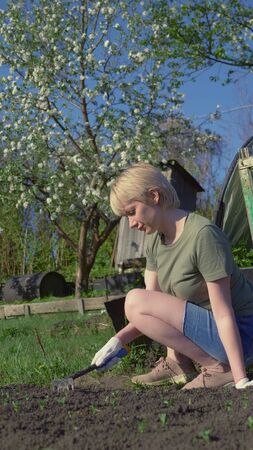 vertically. young beautiful woman loose the beds in the garden. copy spaceの写真素材