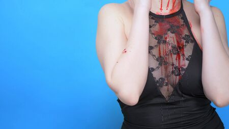 beautiful woman with a bleeding face on a blue background. copy space