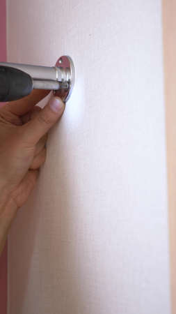 close-up. Young male furniture assembler assembles a built-in wardrobeの写真素材