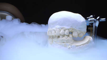 extreme close-up, mock up of human jaw with teeth and dental tools
