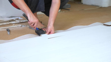 close-up. male hands install white laminate indoorsの写真素材